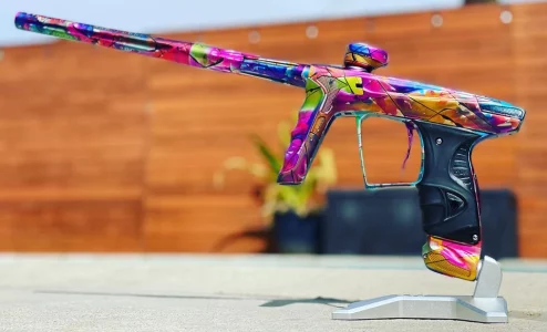 anodized paintball gun sitting in stand