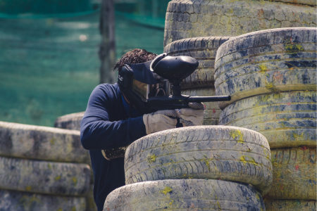 paintball player hiding behind tires
